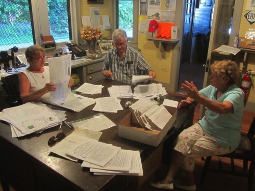 Debby-Lu, Ed, Norma & Clif (behind camera) assembling August newsletters in the Ticket Master's Office. 2015-08-13